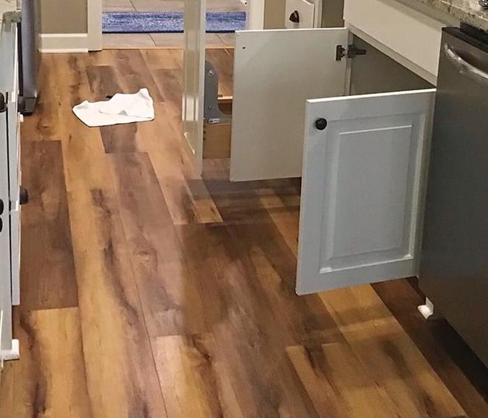 Wet laminate floors in front of a kitchen island