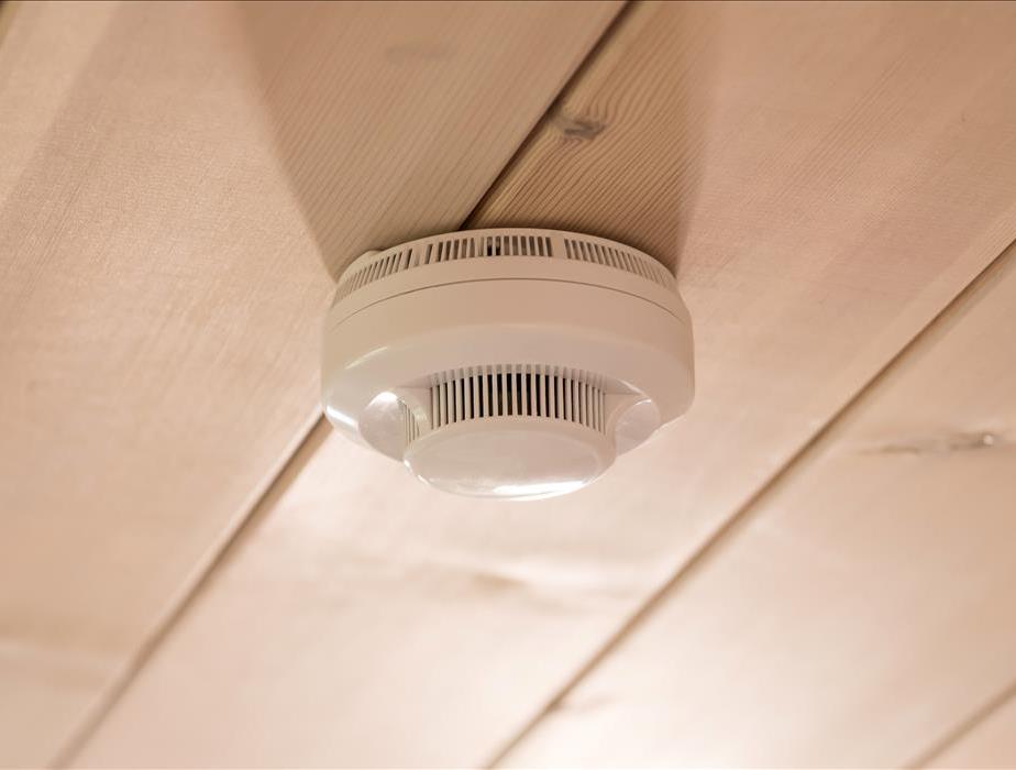 A smoke alarm is attached to a ceiling