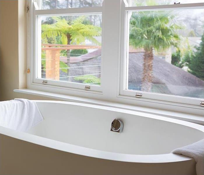 A bathtub sits in front of a window