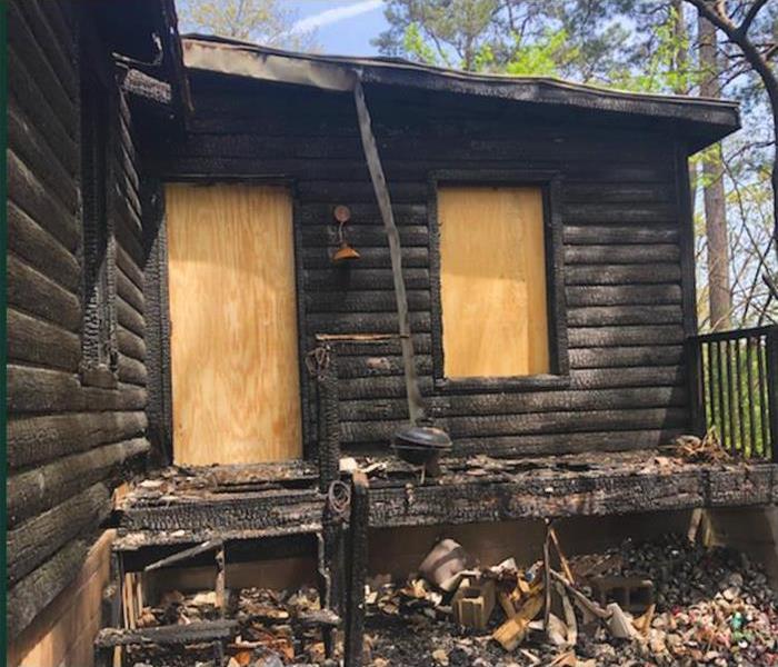 Boards cover the window and door of burned home in Hot Springs, AR